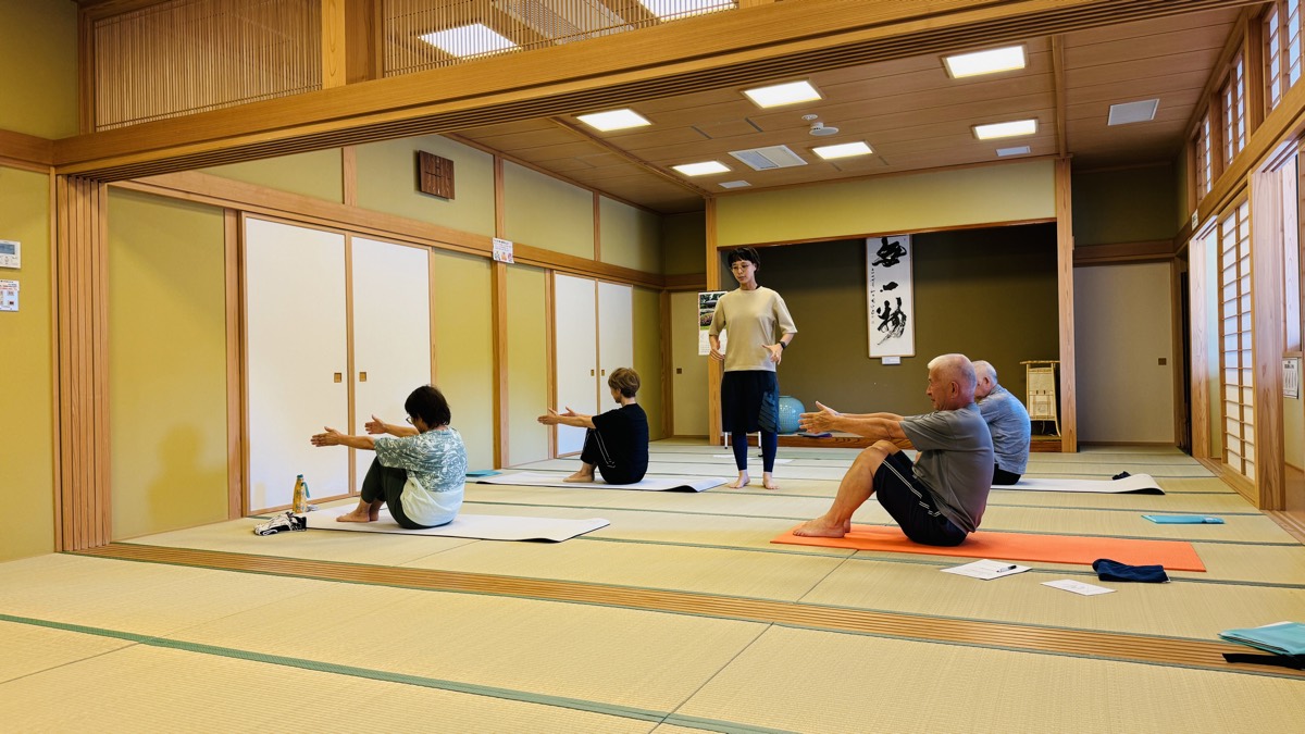 脚を伸ばして座り、バランスの運動に取り組む様子