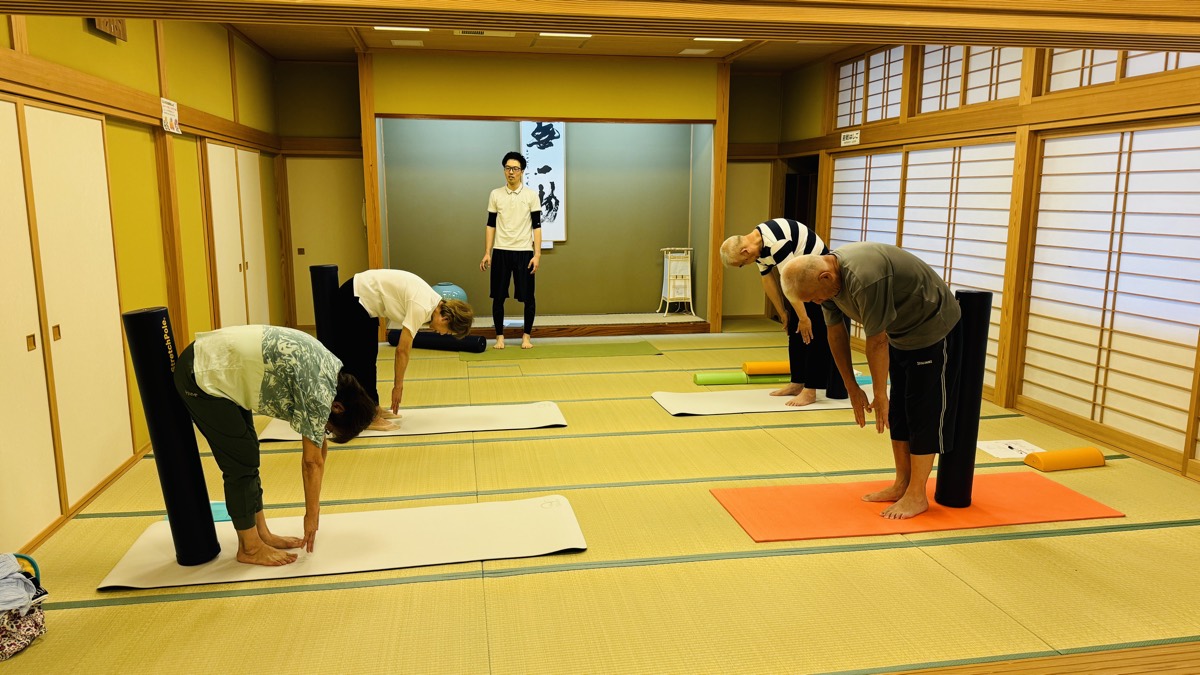 立位で前屈するストレッチに取り組む参加者のみなさん